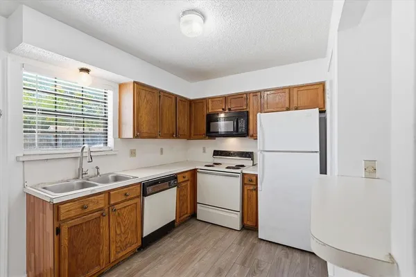 a kitchen with a sink a refrigerator a stove and cabinets