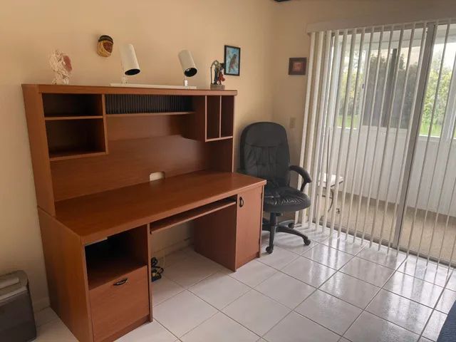 a living room with couches a large window and a rug