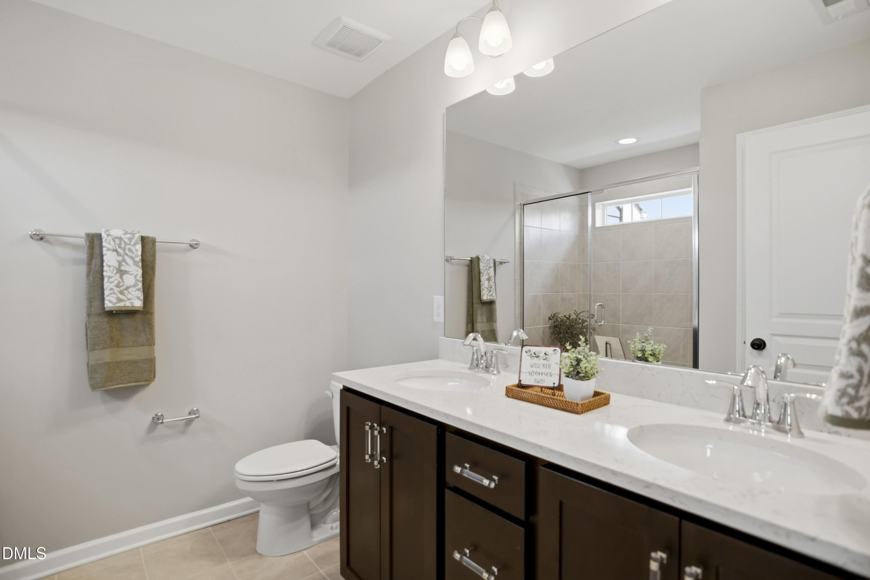 5916 Giddings Street Raleigh, NC 27616 - Photo 20 of 49 a bathroom with a double vanity sink toilet and mirror