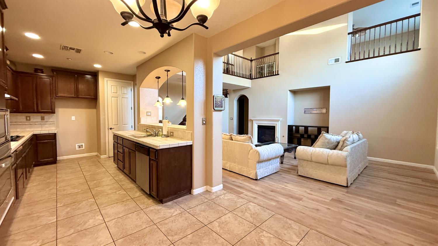 16206 Sand Bar Way Lathrop, CA 95330 - Photo 13 of 32 a living room with furniture a fireplace and a chandelier
