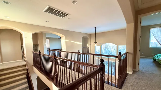 a view of staircase with railing and a chandelier