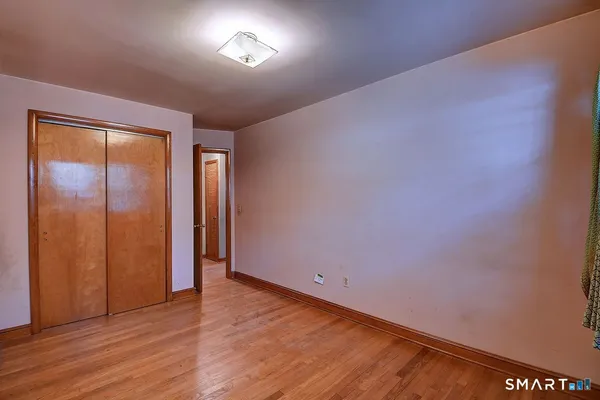 an empty room with wooden floor and closet