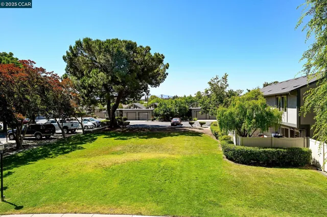 a view of a swimming pool with lawn chairs and a big yard