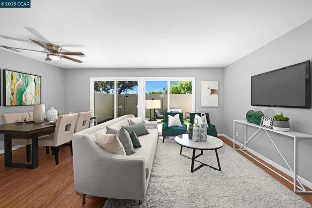 a living room with furniture a large window and a flat screen tv