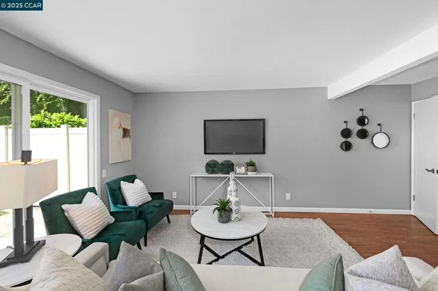 a living room with furniture a flat screen tv and a large window
