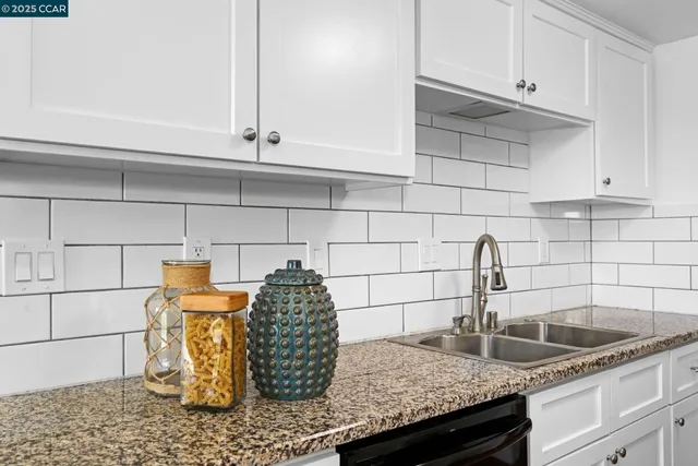 a kitchen with granite countertop a sink and cabinets