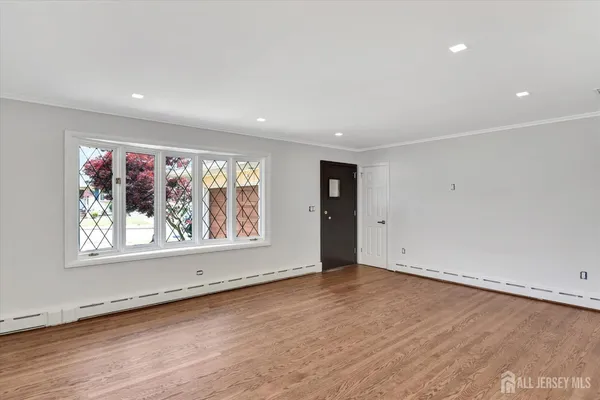 an empty room with wooden floor and window