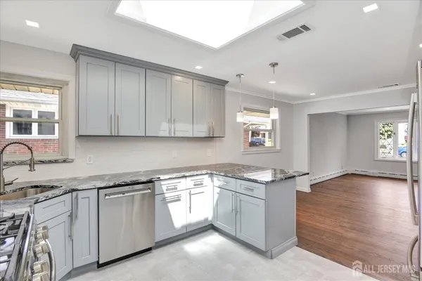 a kitchen with granite countertop cabinets stainless steel appliances and a counter space