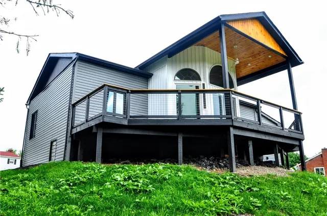 a backyard of a house with wooden fence and large windows
