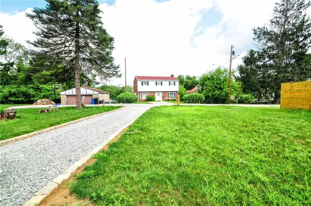 a view of a park with large trees and a houses with a big yard