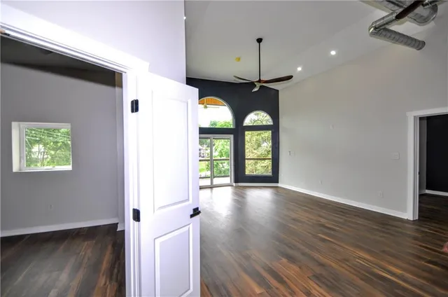 an empty room with wooden floor window and outdoor view