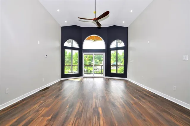 a view of empty room with wooden floor and window