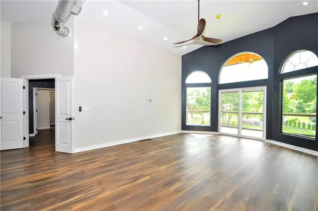 a view of empty room with wooden floor and window