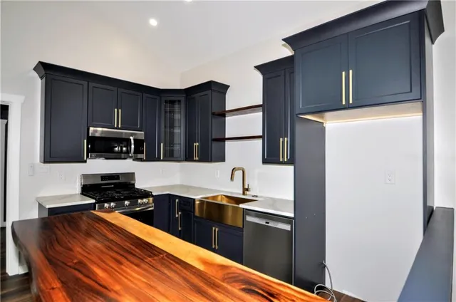 a kitchen with stainless steel appliances granite countertop a stove a sink and a refrigerator