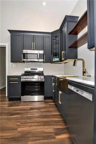 a kitchen with granite countertop a stove and a microwave oven