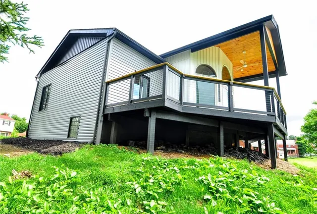 a view of house with yard and balcony