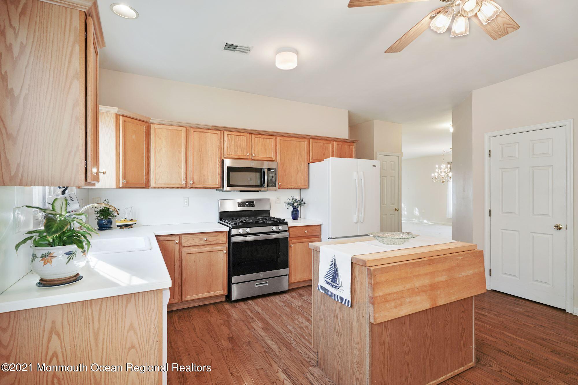 81 Byron Road Brick, NJ 08724 - Photo 17 of 51 a kitchen with stainless steel appliances a stove a microwave a sink a refrigerator white cabinets and wooden floor
