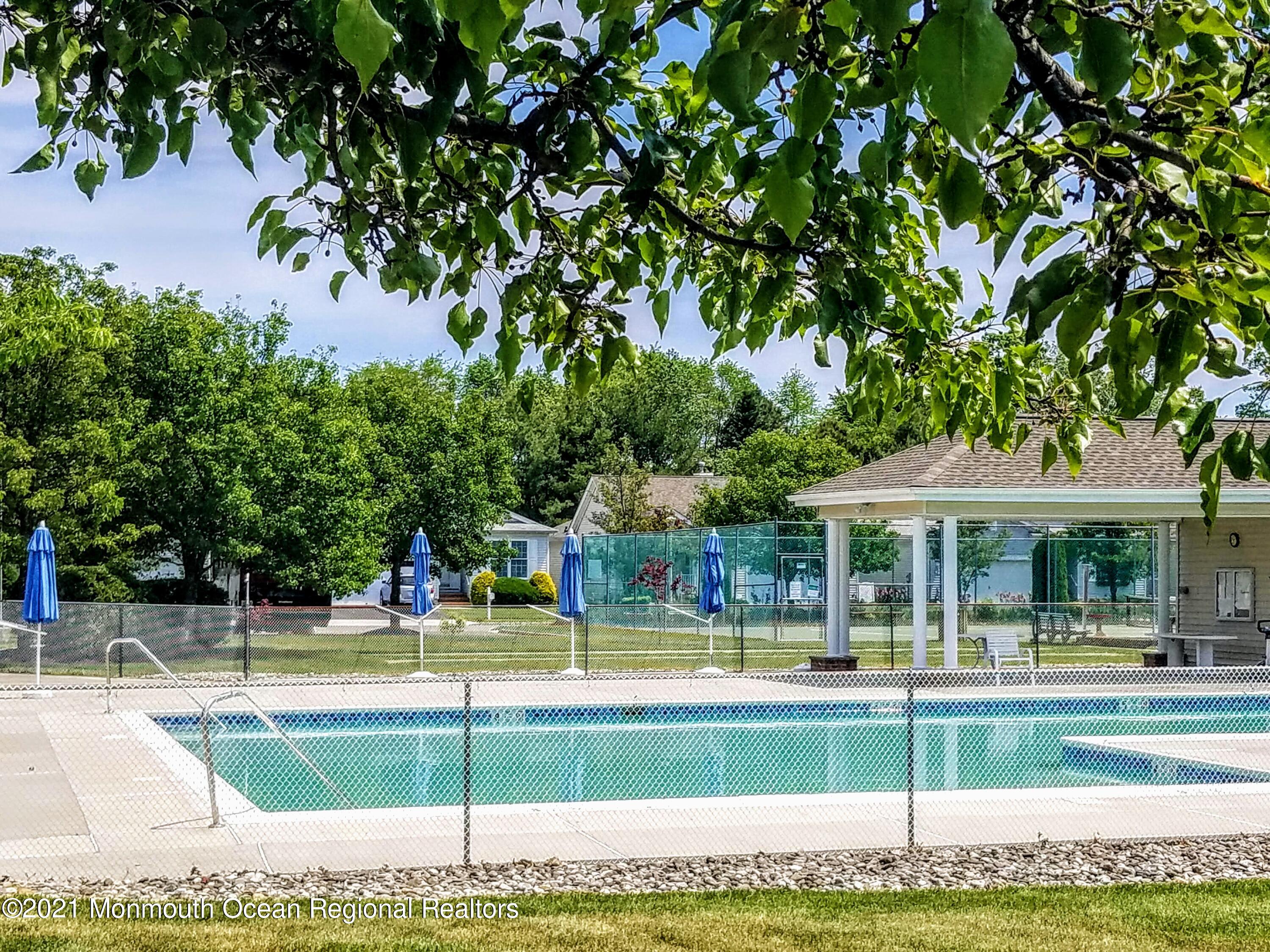 81 Byron Road Brick, NJ 08724 - Photo 50 of 51 a view of a swimming pool with a lawn chairs under an umbrella