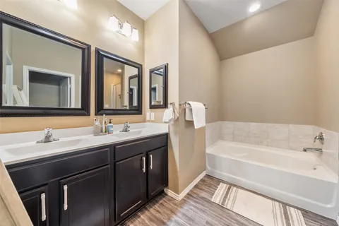 a bathroom with a tub sink and mirror