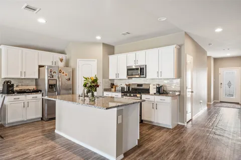 a kitchen with white cabinets and stainless steel appliances