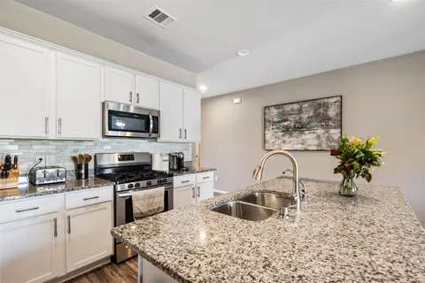 a kitchen with a sink a stove and cabinets