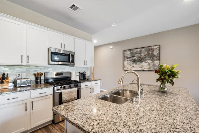 a kitchen with a sink a stove and cabinets