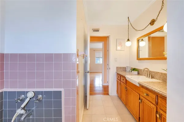 a bathroom with a double vanity sink a mirror and a bathtub