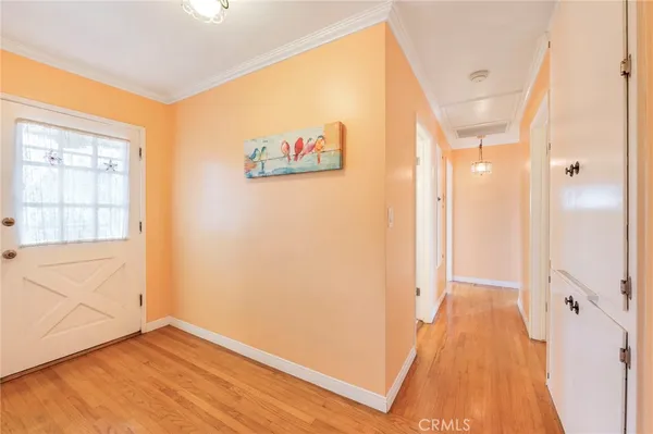 a view of a hallway with wooden floor and cabinet