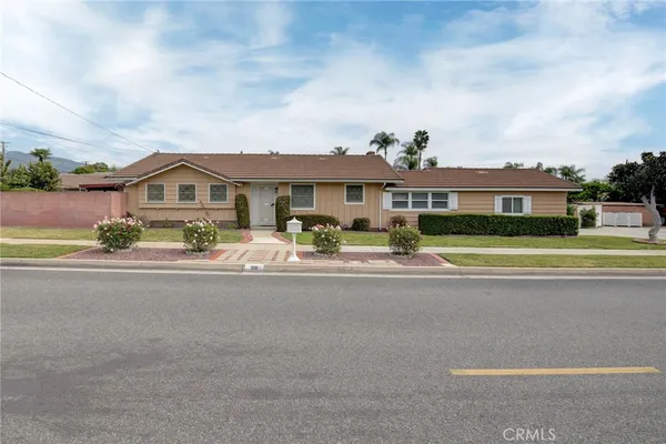 a front view of a house with a garden and plants
