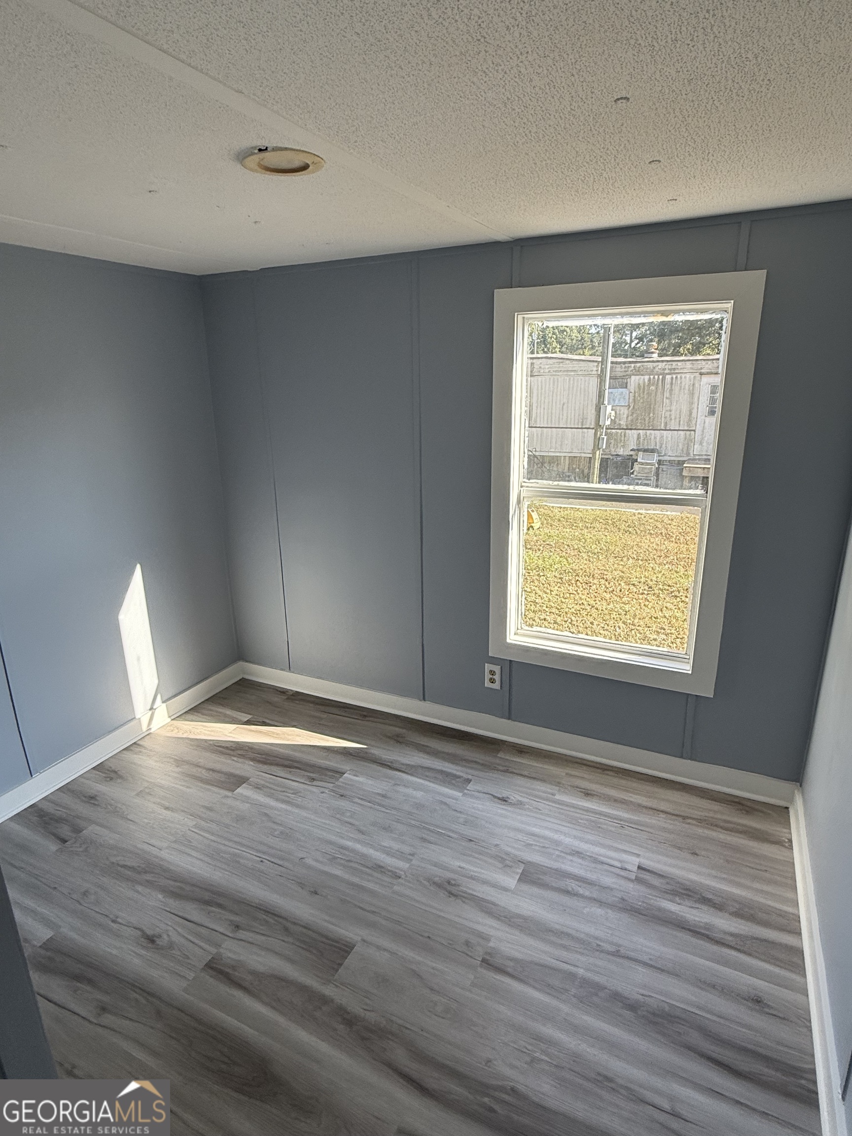8410 Hawkinsville Road Macon, GA 31216 - Photo 16 of 22 a view of an empty room with wooden floor and a window