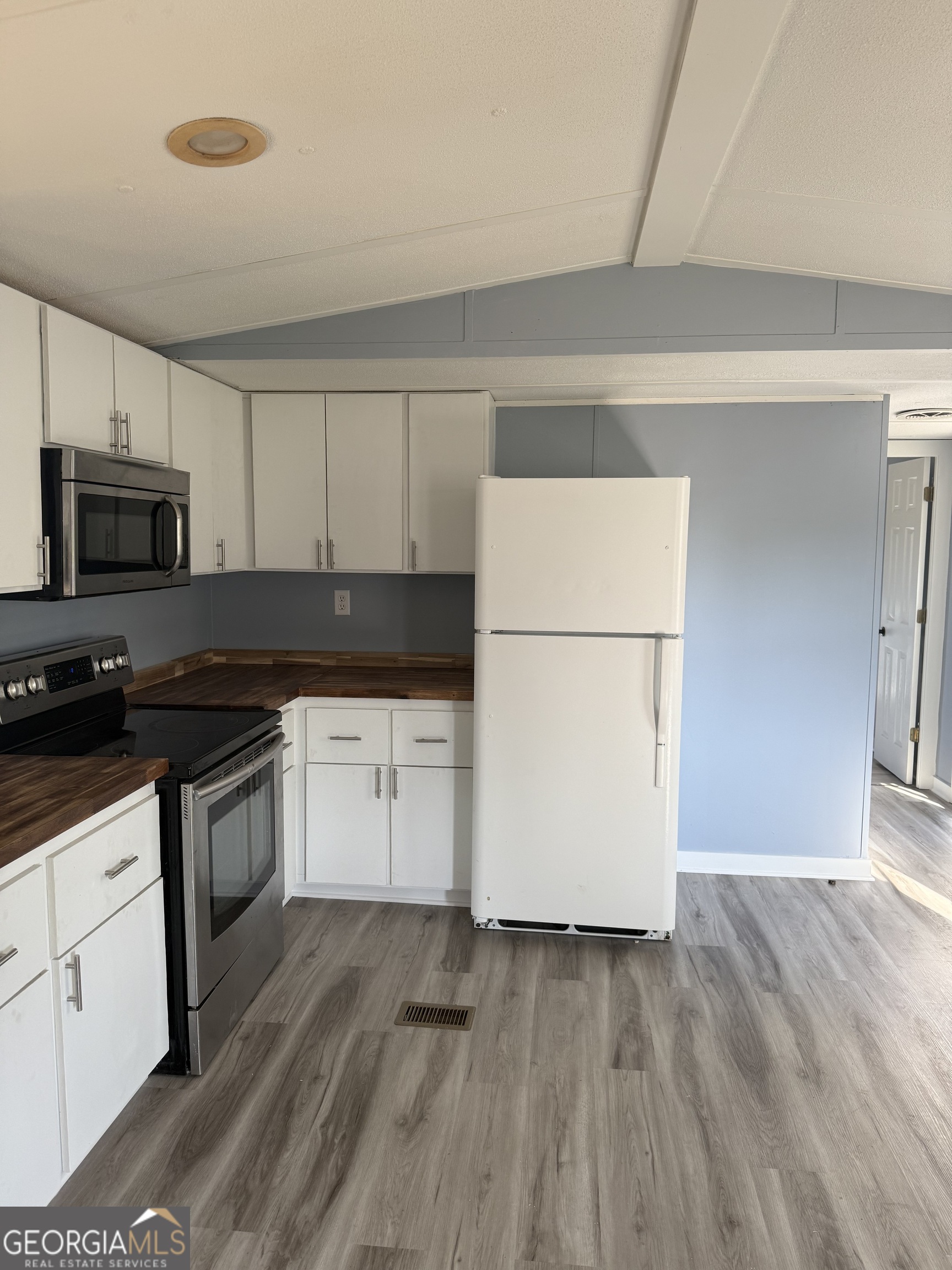 8410 Hawkinsville Road Macon, GA 31216 - Photo 6 of 22 a kitchen with granite countertop white cabinets and wooden floor