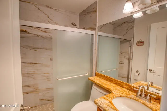 a bathroom with a sink toilet and shower