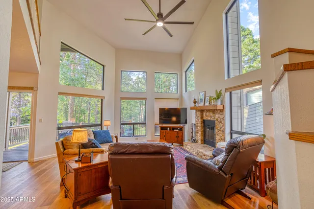 a living room with fireplace furniture and a large window