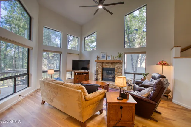a living room with furniture a large window and a flat screen tv