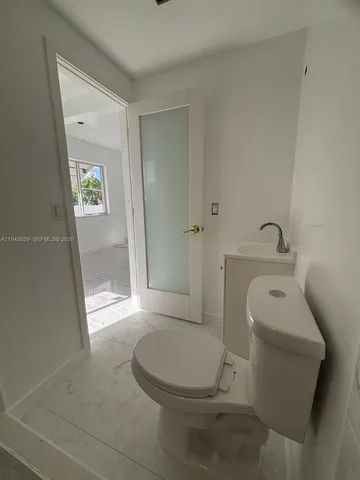 a white toilet sitting next to a bathroom sink