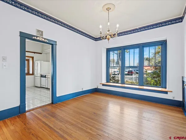 a view of a bedroom with wooden floor and a window