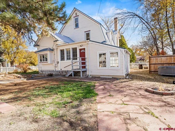 a view of a house with a yard and pathway