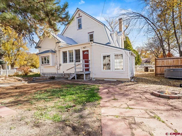 a view of a house with a yard and pathway