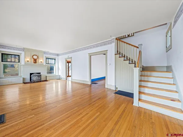a view of empty room with wooden floor and window