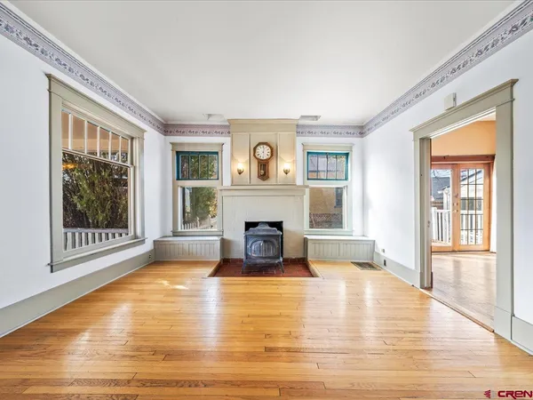 a view of a livingroom with a fireplace wooden floor and windows