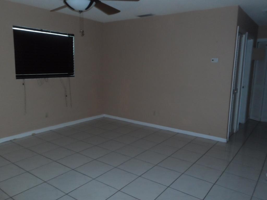 336 Southwest 1st Street, Unit B8 Pompano Beach, FL 33060 - Photo 3 of 11 an empty room with wooden floor cabinet and flat screen tv