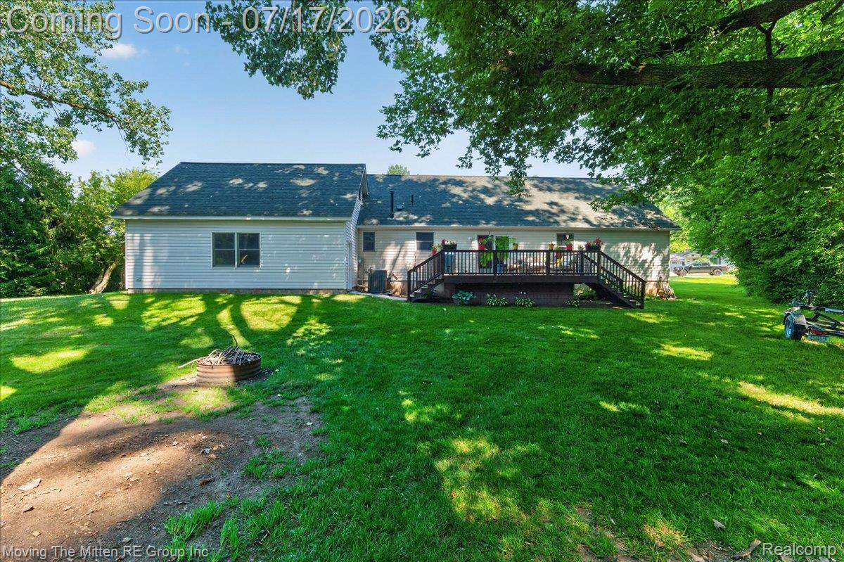 40162 Alden Road Belleville, MI 48111 - Photo 50 of 67 Expansive backyard featuring a manicured lawn, a multi-level wood deck with railings, and mature trees providing shade