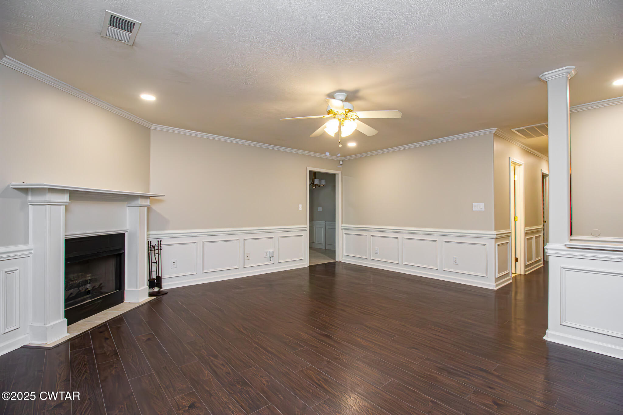 88 Rooker Drive Jackson, TN 38305 - Photo 4 of 20 an empty room with wooden floor fireplace and fan