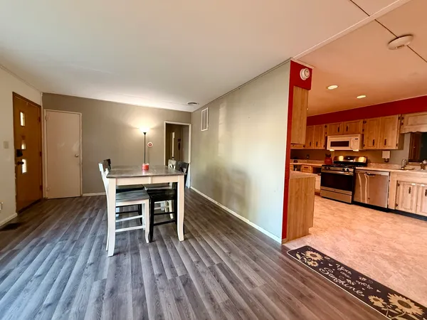 a kitchen with stainless steel appliances kitchen island wooden floors and wooden cabinets