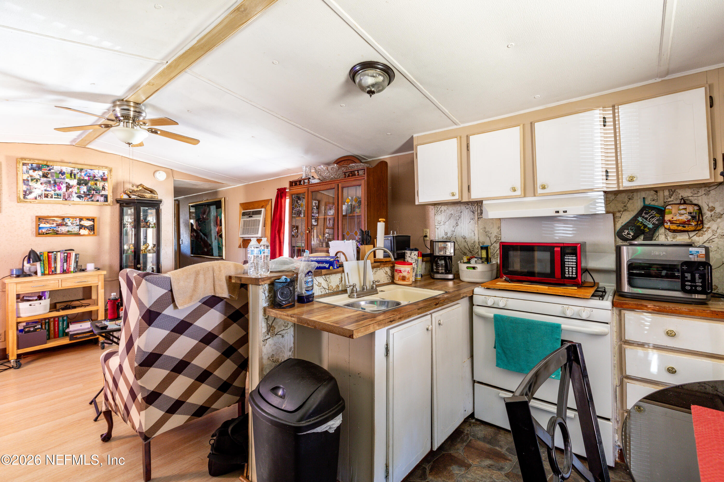11830 Southwest 45th Terrace Lake Butler, FL 32054 - Photo 14 of 16 a kitchen with stainless steel appliances kitchen island granite countertop a stove a sink dishwasher and white cabinets with wooden floor