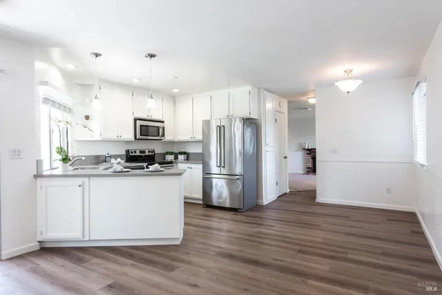 a kitchen with stainless steel appliances a refrigerator sink and microwave