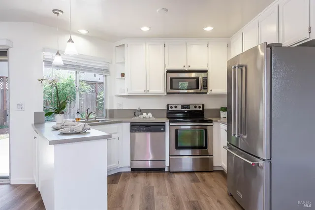 a kitchen with kitchen island granite countertop a refrigerator stove and sink