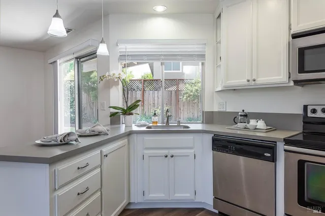 a kitchen with granite countertop white cabinets and a sink