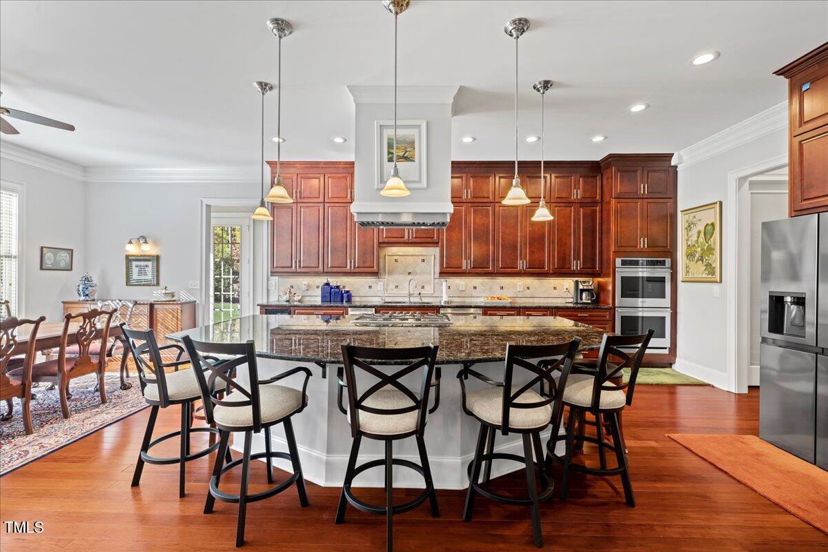 2304 Gresham Lake Road Raleigh, NC 27615 - Photo 14 of 55 a kitchen with stainless steel appliances granite countertop a kitchen island a stove a table and chairs