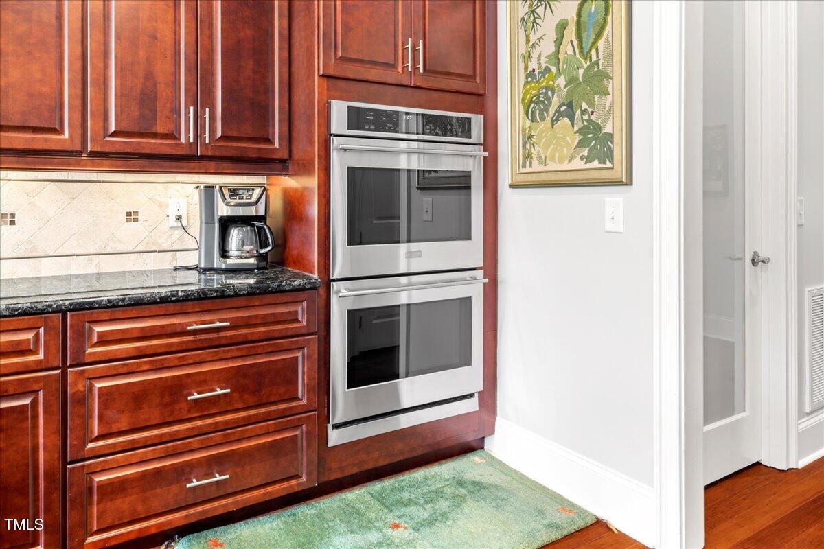 2304 Gresham Lake Road Raleigh, NC 27615 - Photo 17 of 55 a kitchen with granite countertop white cabinets and stainless steel appliances